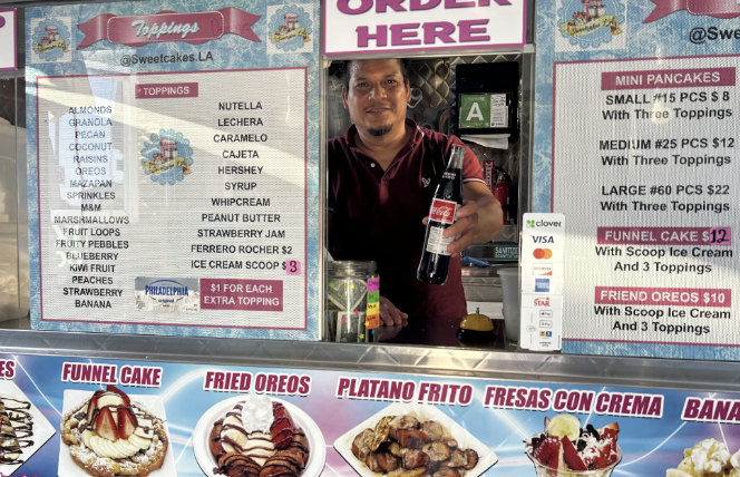 Dessert vendor holding a Coca-Cola bottle at a food stand