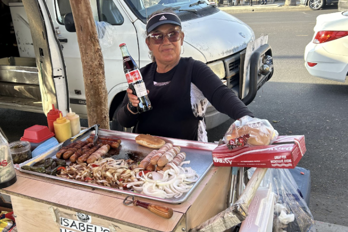 Street food vendor holding a Coca-Cola bottle